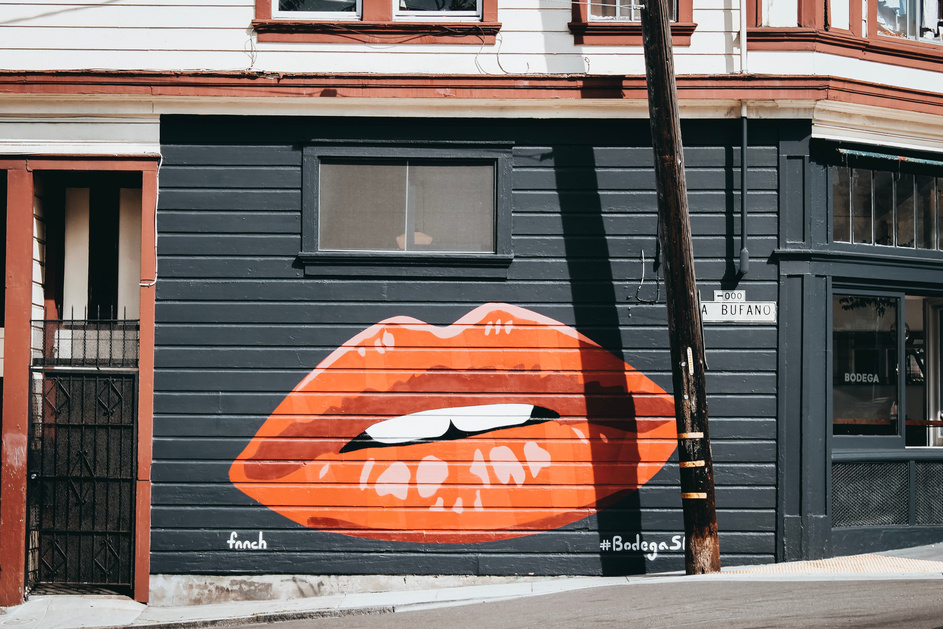 Black and Orange Lips Painted Building Wall