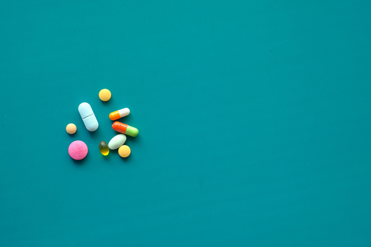 Close up of Colorful Pills Spilling on Green Background